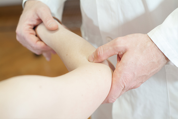 An image of a physio therapist heling a woman with joint pains